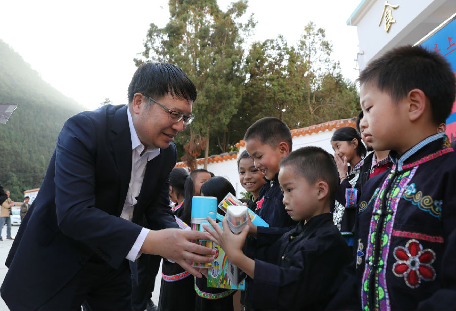 (校党委副书记、副校长常保国向汤谷民族小学小学生捐赠文具)